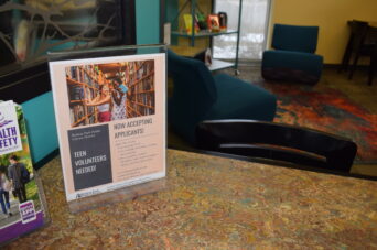 Photo of a flyer asking for Teen Volunteers on a table in the Teen Space